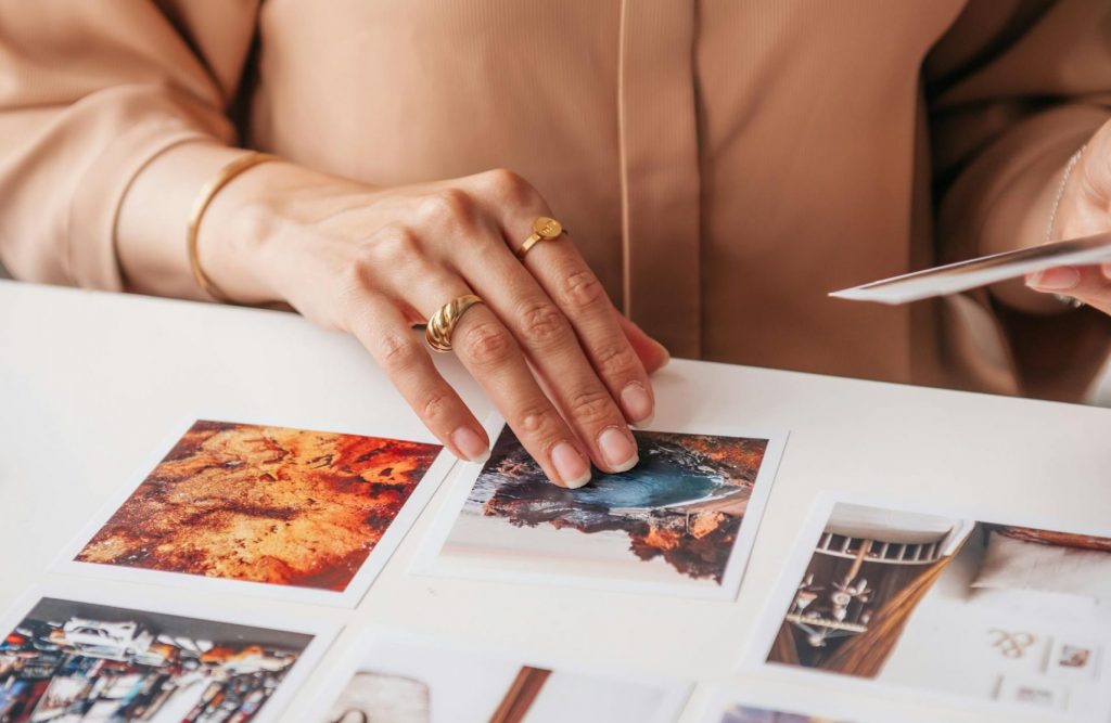 Mains triant des tirages photo sur une table de travail